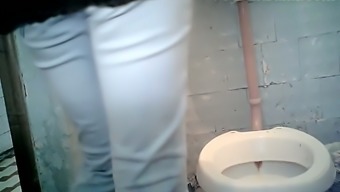 Brunette white lady in white jeans pisses in the toilet room