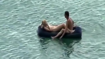 Group of nudist in air mattress in the water