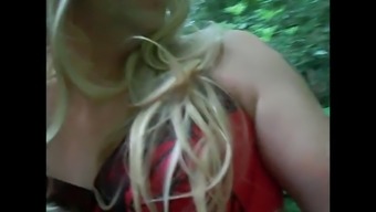 Blonde t-girl plays with her tool in the woods
